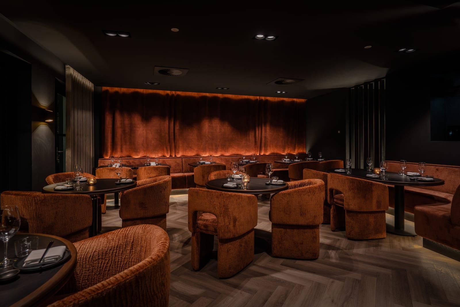 Het restaurant van ROKU Oisterwijk, met fluwelen stoelen en gedekte tafels